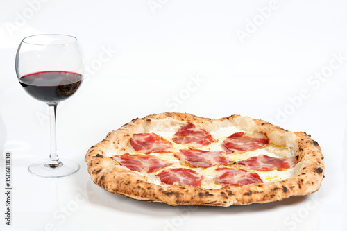 real italian pizza margherita with pork loin mozzarella cheese, in a white background whit a glass of delicious Italian red Chianti wine