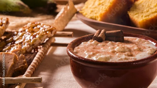 Brazilian dessert canjica of white corn with cinnamon in bowl. Selective focus. Table of brazilian festa junina with smoke. photo