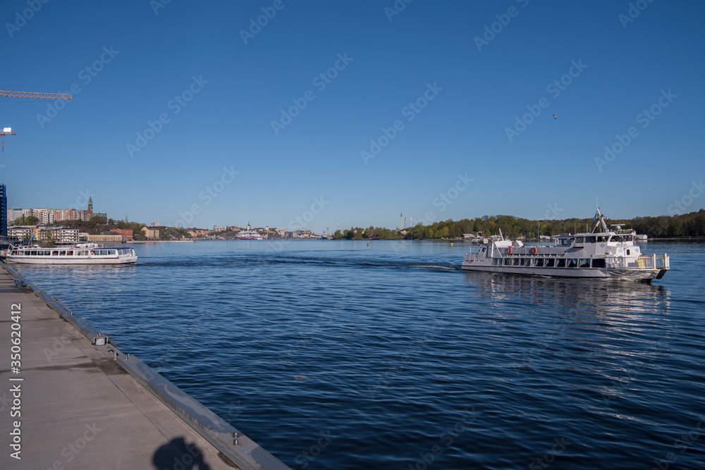 Nacka Strand harbor view with boats and monument in the district Nacka a sunny spring morning in Stockholm. Nacka Strand harbor view with boats and monument in the district Nacka a sunny spring morning in Stockholm.