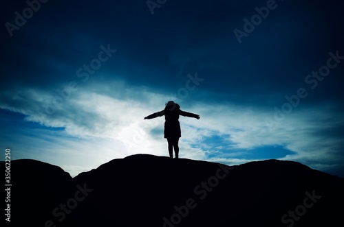 silhouette of a woman on a rock