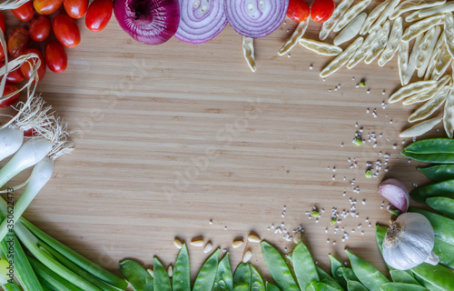 Cherry tomatoes, onions, Italian pasta, green beans, arranged in a circle on a bamboo sheet. Healthy ingredients in the atlas. Kitchen composition before cooking, preparation.