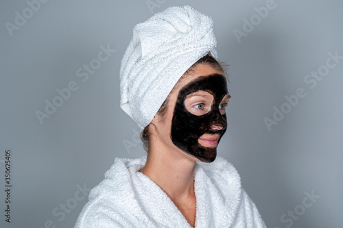 Young woman with black facial mask