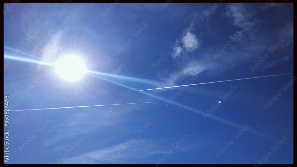 Low Angle View Of Bright Sun In Blue Sky - obrazy, fototapety, plakaty 
