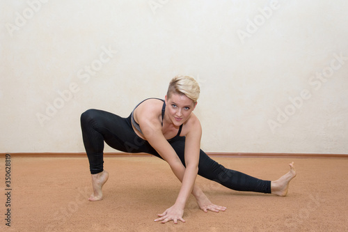 A photo of a girl doing fitness stretches on the floor at home. self-isolation, quarantine,