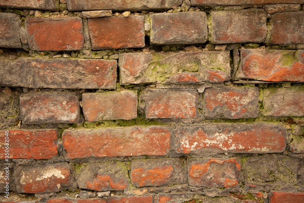 The old city wall is made of red brick with relief. Bricks are laid in horizontal rows. Textured background. Layout The old city wall is made of red brick with relief. Bricks are laid in horizontal rows. Textured background. Layout