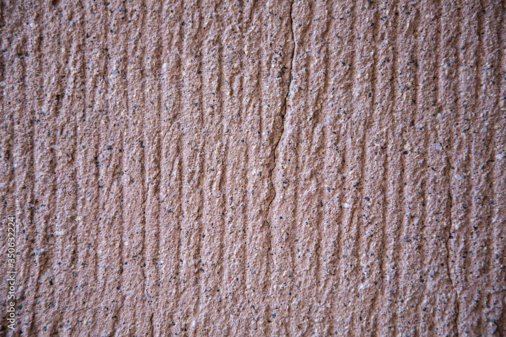 The stone relief background of the wall is gray-brown. Texture for the design. Empty space for text The stone relief background of the wall is gray-brown. Texture for the design. Empty space for text