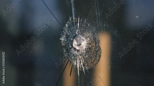 Armored glass shot through by a bullet. Close-up. Crime scene. Expert criminalist photo