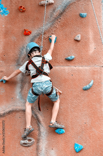 The boy is engaged in rock climbing. photo