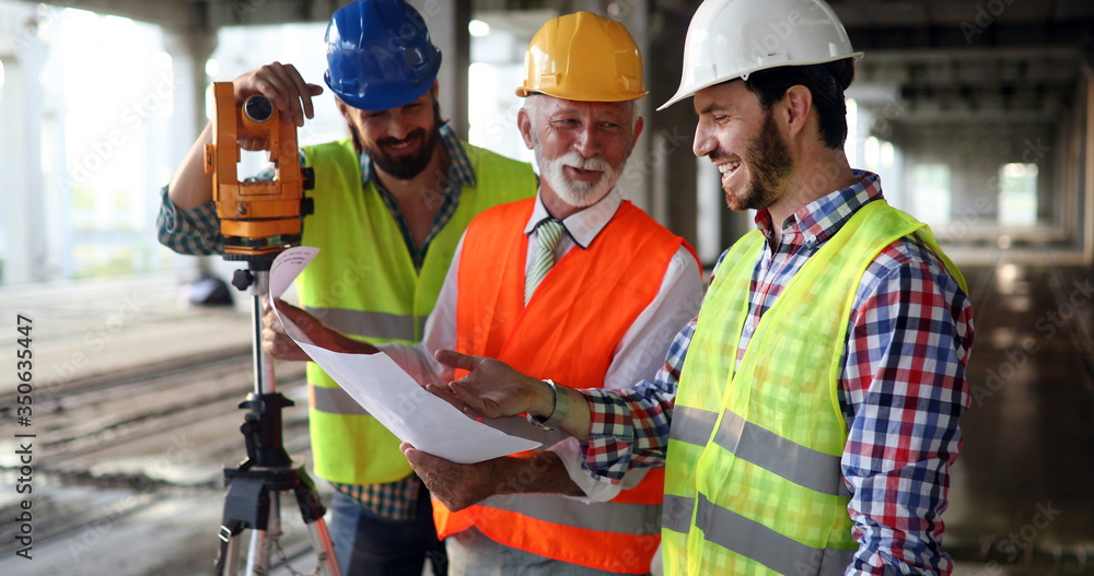 Team of construction engineers, architects working on building site Team of construction engineers, architects working on building site
