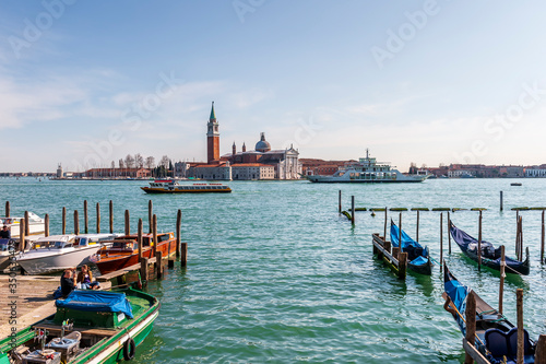 gondolas and traffic on the lagoon and the island of San Giorgio Maggiore in the background in the lagoon of Venice in Veneto, Italy