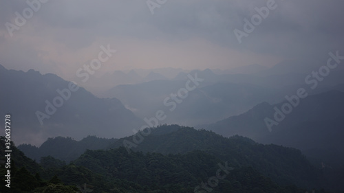 Beautiful glorious colourful sunrise in the national park over the mountains in China, mysterious landscape with hills, clouds, mist and colour shades, trekking and hiking outdoors, peak summit 