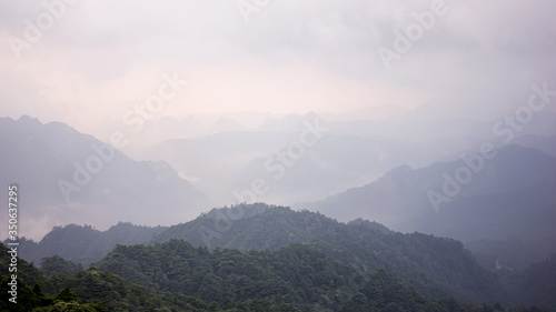 Beautiful glorious colourful sunrise in the national park over the mountains in China, mysterious landscape with hills, clouds, mist and colour shades, trekking and hiking outdoors, peak summit 