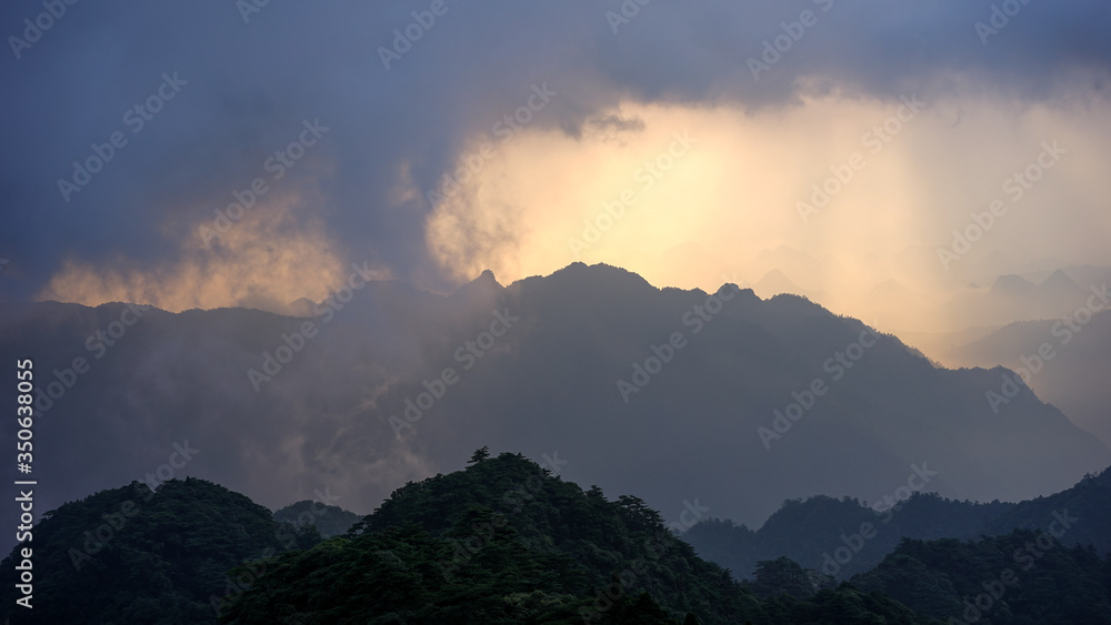 Beautiful glorious colourful sunrise in the national park over the mountains in China, mysterious landscape with hills, clouds, mist and colour shades, trekking and hiking outdoors, peak summit
