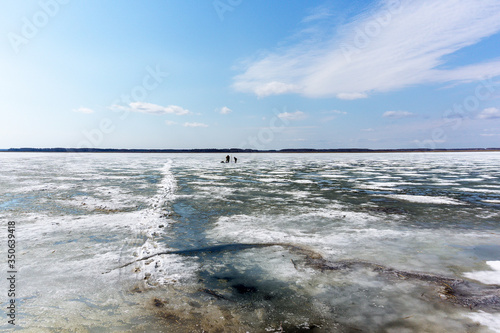 winter fishing fishermen catching fish under the ice in winter ice fishing. landscape  lake  snow