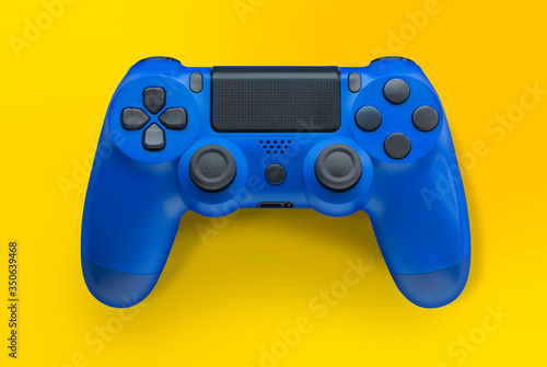 Blue video game controller isolated on a yellow background