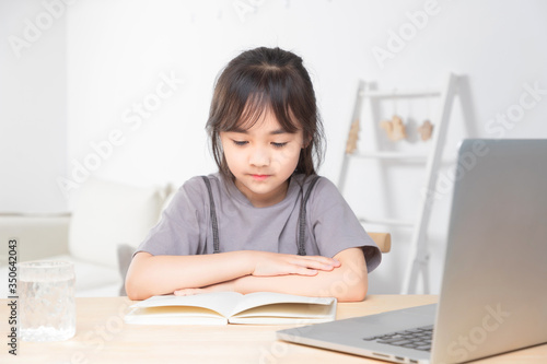 Asian little girl surfing internet at home