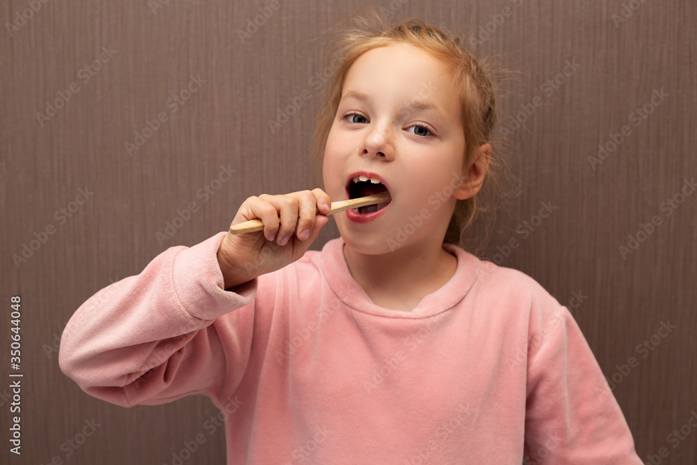 Redhead girl child brushes her teeth. Redhead girl child brushes her teeth.