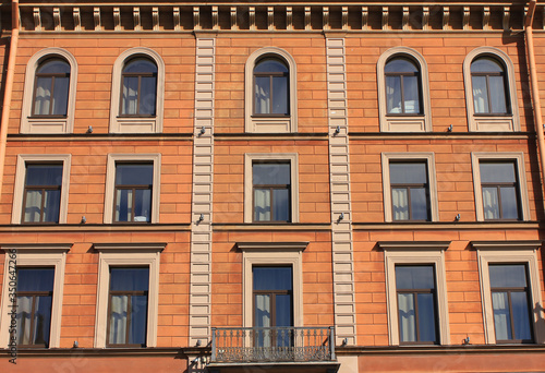 Building facade architecture of old residential house outside. Multi-story old facade, brown color walls with simple windows in row. Apartment exterior close up, classic european house close up view