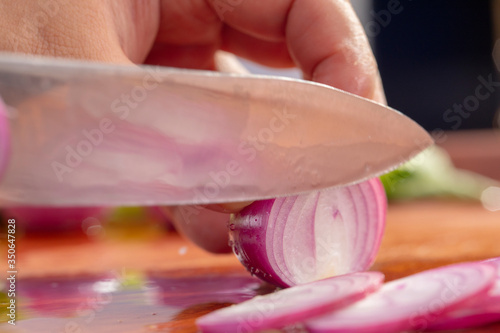 Close-up chef is cutting red onion