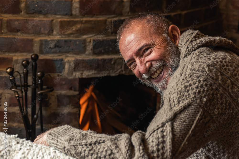 older man lighting the fireplace in the house older man lighting the fireplace in the house