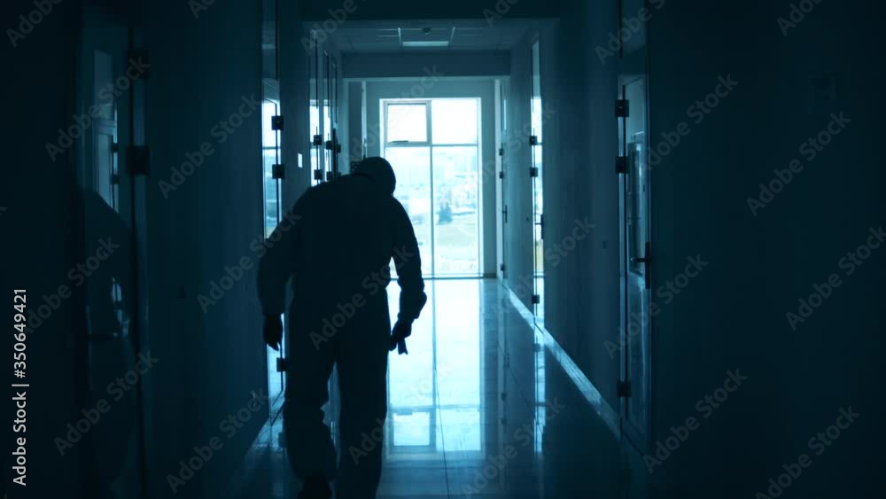 Tired doctor is having a break while leaning onto the wall Tired doctor is having a break while leaning onto the wall