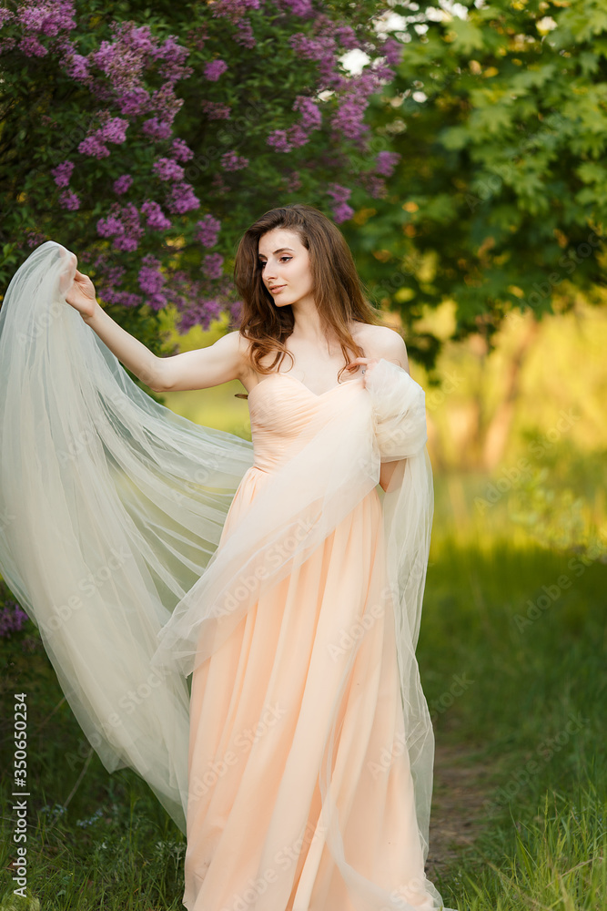 Beautiful bride in a vintage dress in spring lilac garden
