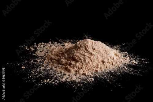 Spilled brown powder looking like unrefined heroin, isolated