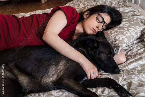 A girl sleeps peacefully next to her dog.