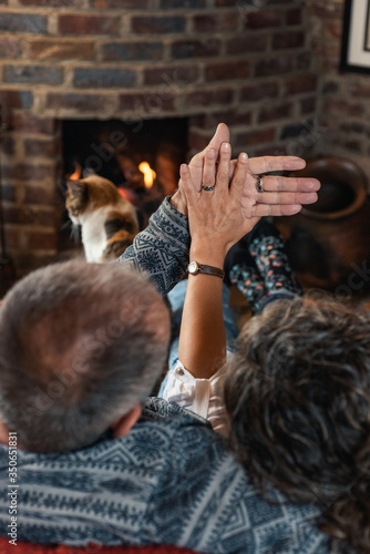 older couple rested in front of the fireplace with their cat