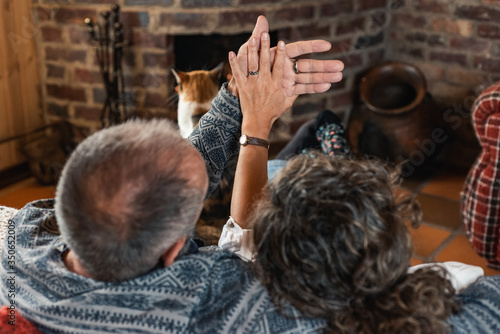 older couple rested in front of the fireplace with their cat photo