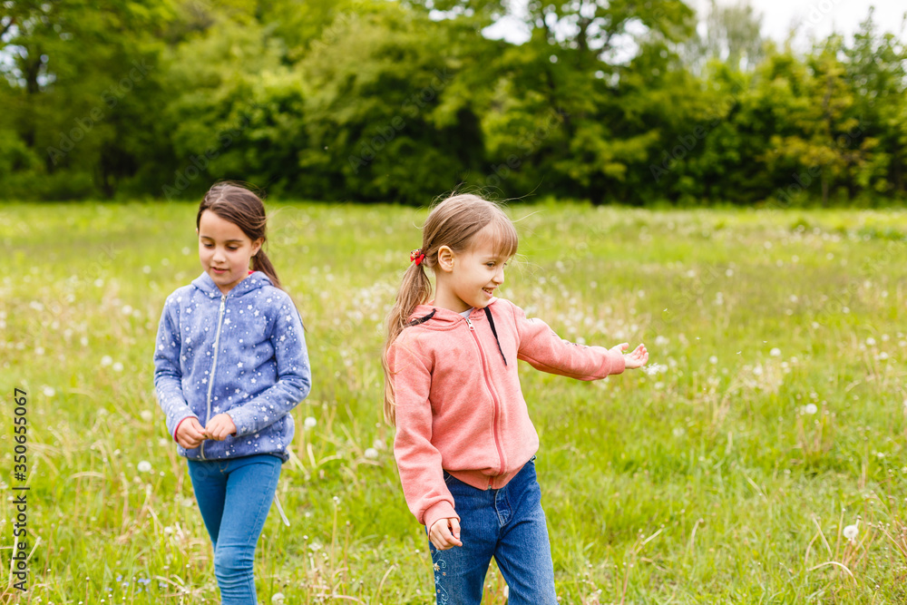 Two sisters hug one another outdoors, happy family Two sisters hug one another outdoors, happy family