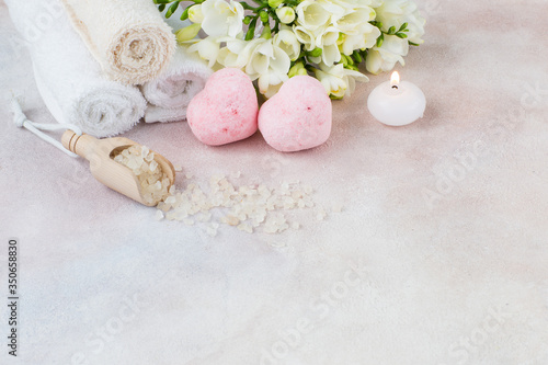 towels, candle, salt, a bouquet of freesia and soap - items for spa treatments