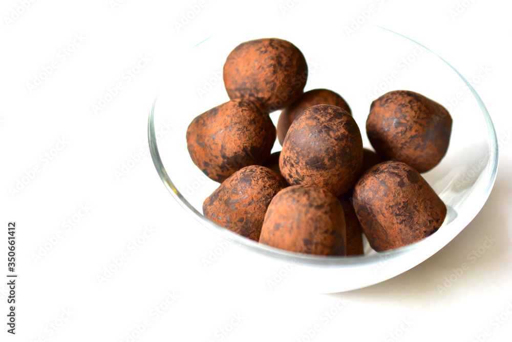 Chocolate truffles in a glass bowl on a white background Chocolate truffles in a glass bowl on a white background