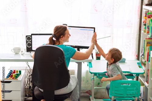 Mother with kid working from home during quarantine. Stay at home, work from home concept during coronavirus pandemic