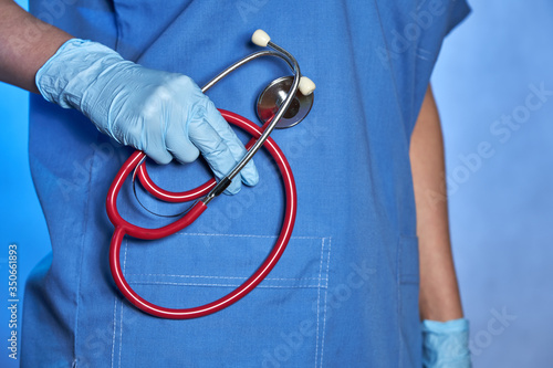 Hand of a doctor in medical glove with stethoscope, closeup, Coronavirus epidemic COVID-19