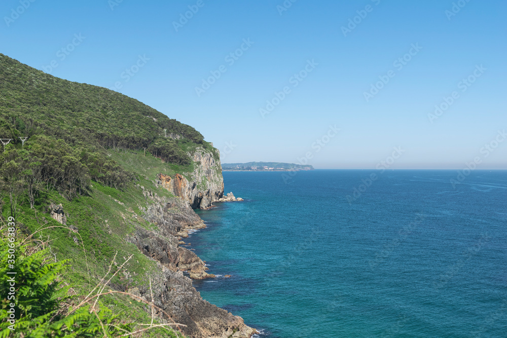 Fototapeta premium cliffs on the coast with the turquoise ocean and details of a lighthouse