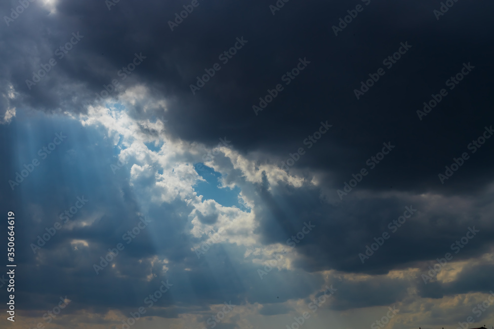 Heavenly Sun Rays Through Dark Clouds Against The Blue Sky. selective focus