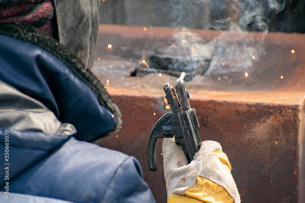 Metal welding by a manual electric welding machine.