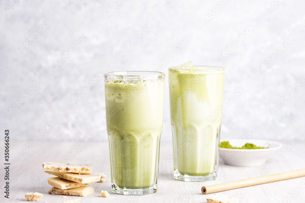 Fototapeta premium Glasses of matcha latte with coconut milk and white chocolate on wooden and marble background
