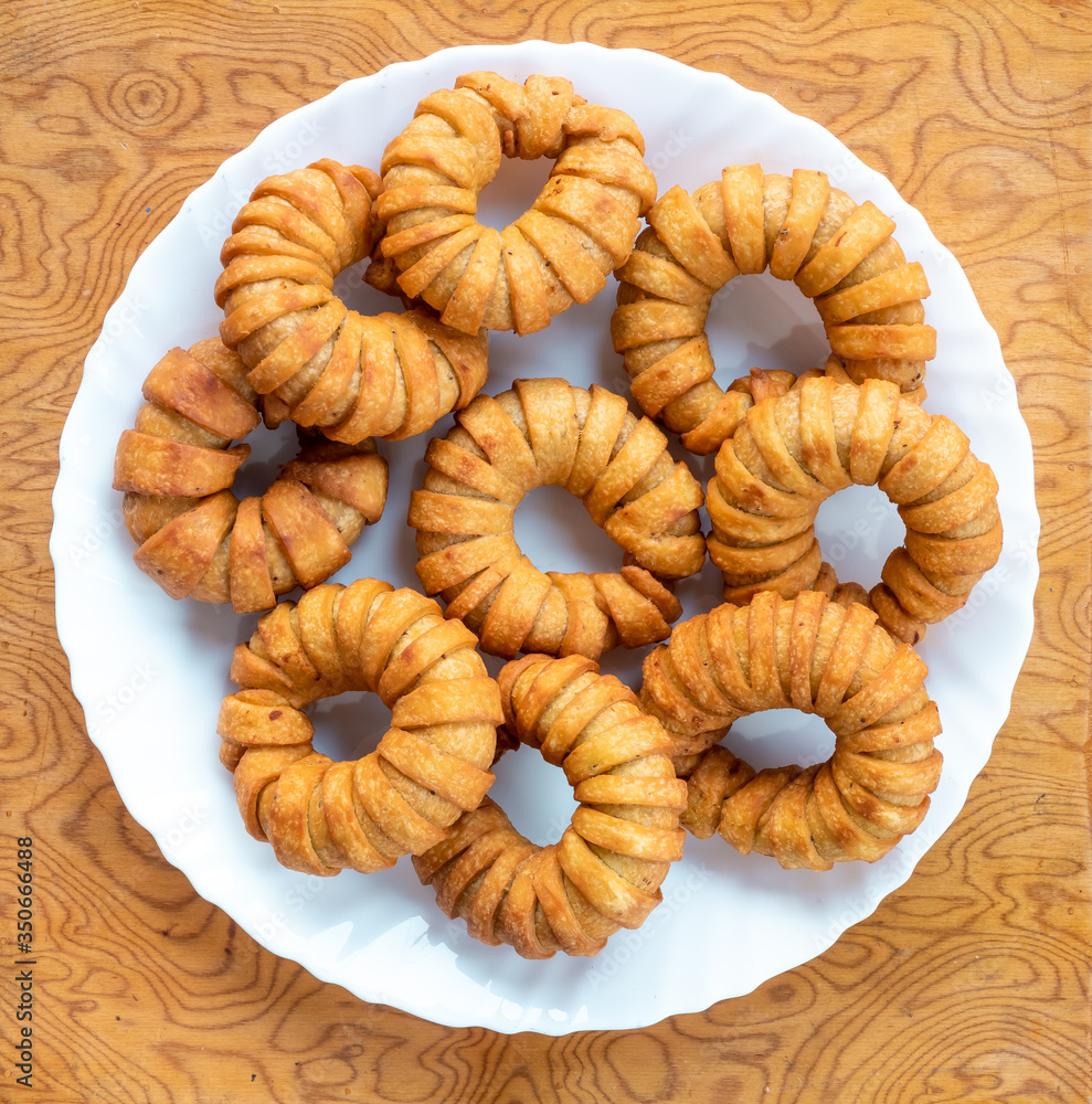 Fresh Ring Kachori, a homemade spicy Indian snack common in places with Indian diaspora and other South Asian diaspora, on table in a white plate..selective focus