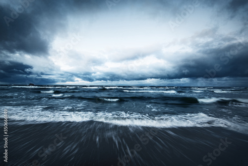 Fototapeta Naklejka Na Ścianę i Meble -  Storm clouds above the Baltic sea in winter, long exposure. Dramatic sunset sky, waves and water splashes. Dark seascape. Germany