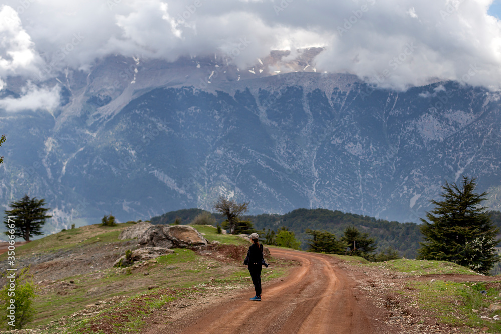 Fototapeta premium A woman photographer watching the landscape in the mountains of Antalya