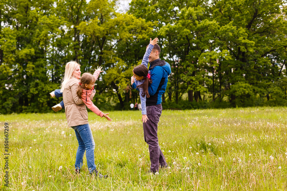 Fototapeta premium young familiy are walking through a green field
