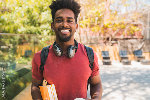 Afro university student holding his books. photo