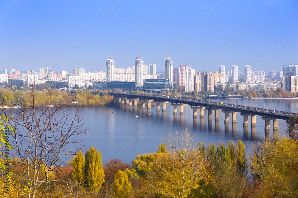 View of the Dnieper River in the city of Kiev. Potona Bridge and the modern buildings of the city. 