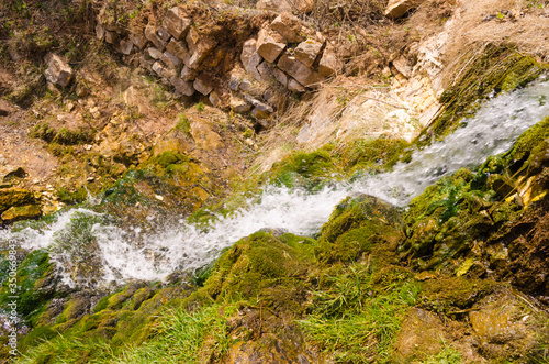 Waterfall in the mountains, moss and stone mountain river