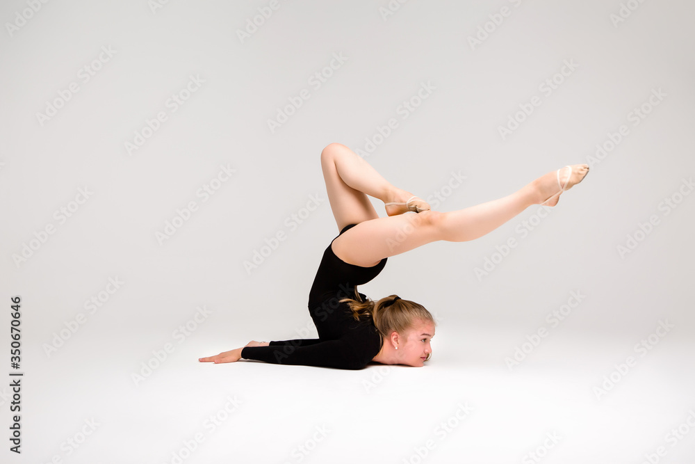 young beautiful girl gymnast on a white background. a young girl is engaged in gymnastics on a white background. young beautiful girl gymnast on a white background. a young girl is engaged in gymnastics on a white background.