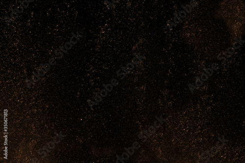Black abstract background with yellow gold dust.