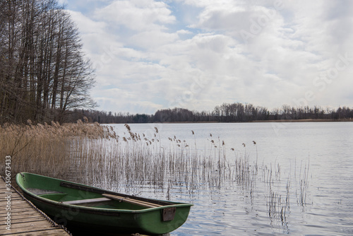 Fotografie, Obraz Old boat on lake. Cloudy Spring Day.