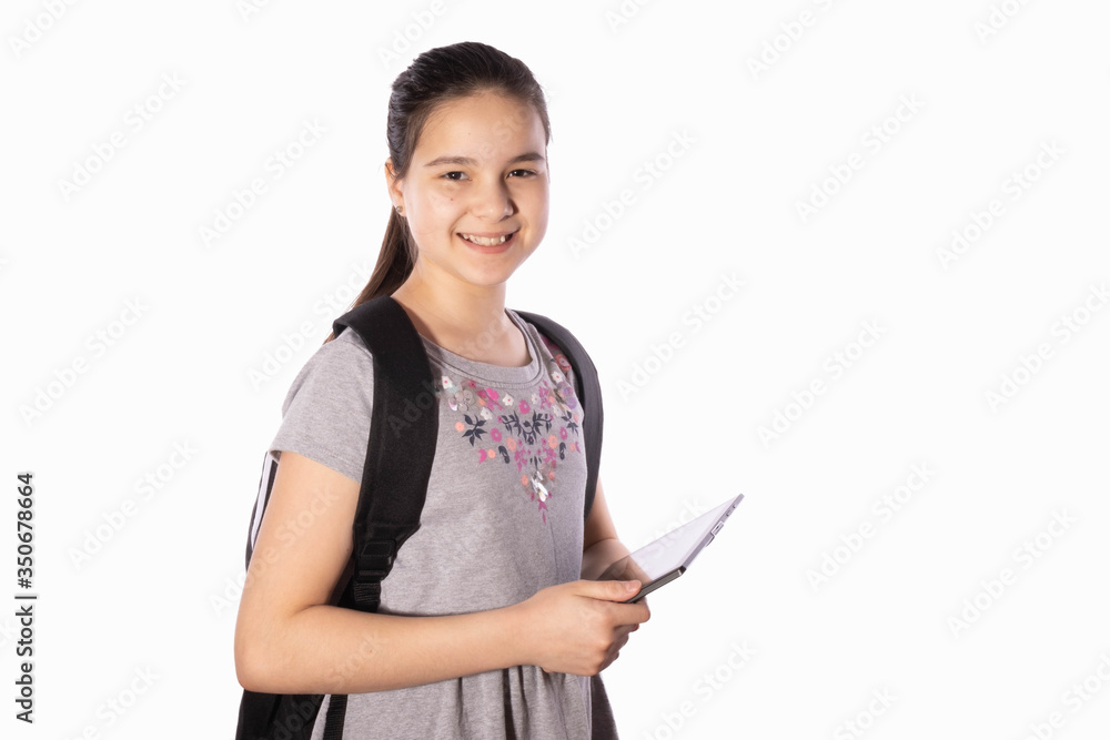 schoolgirl smiles, holds a tablet in her hands and looks away schoolgirl smiles, holds a tablet in her hands and looks away